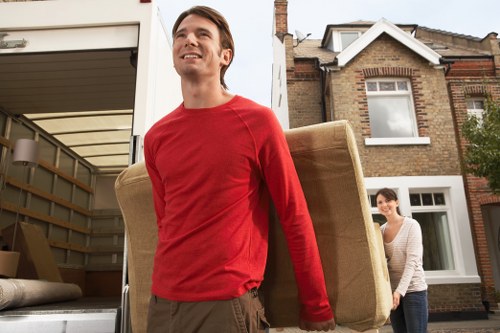 Man with van loading furniture in Beckton near apartment buildings