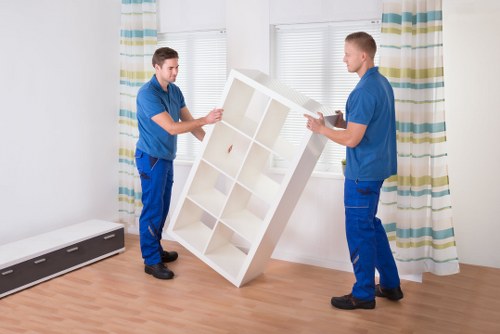 Professional movers handling furniture in a Beckton apartment building